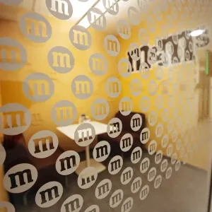 Meetingraum mit gelber M&M’s-Wand und zwei Sitzplätzen in warmen Farbtönen