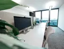 	Reihe moderner Arbeitsplätze mit großen Monitoren und Blick ins Freie