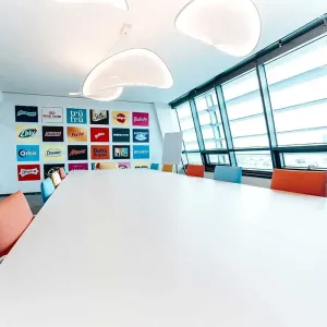 Großer Besprechungsraum mit Markenwand und farbigen Stühlen