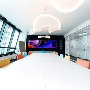 Konferenzraum mit großer Leinwand und farbenfrohen Stühlen