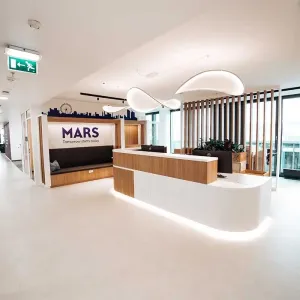 Moderner Empfangsbereich von Mars Austria mit hellem Holz und beleuchtetem Tresen