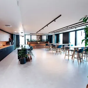 Großer Sozialraum mit Küche, Pflanzen und hohen Sitzbereichen