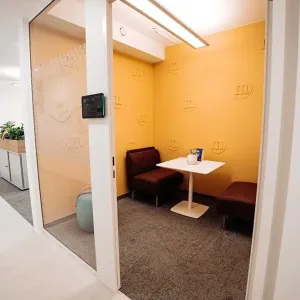 Verglaster Besprechungsraum mit gelber M&M’s-Wanddekoration und weißen Punkten