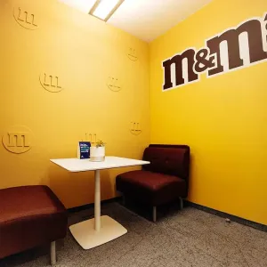 Kleiner Besprechungsraum mit gelber Wand und braunen Sitznischen