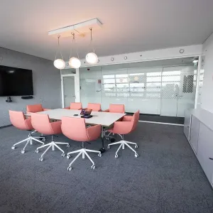 Royal Canin Meetingraum mit rosa Sesseln und großem Monitor