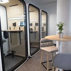 Großraumbüro mit Pflanzen und Schriftzug „We. Love. Pets.“ an der Wand