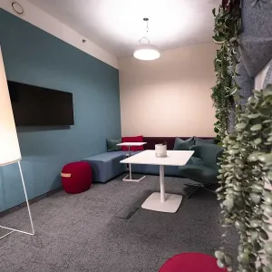 Gemütlicher Lounge-Bereich mit Sofa, Pflanzenwand und modernem Lichtkonzept