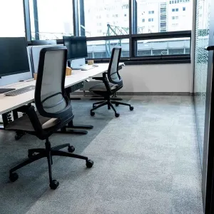 Modernes Großraumbüro mit ergonomischen Arbeitsplätzen und großen Fenstern