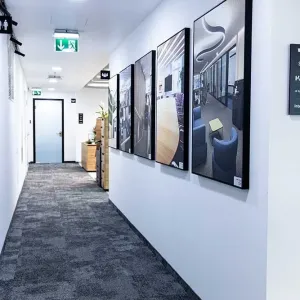 Flur mit gerahmten Architekturmotiven und Wegweiser-Beschilderung