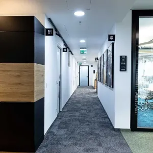 Büroküche mit Kaffeemaschine, dahinter heller Gang mit Notausgangsschild