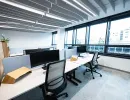 Ergonomische Arbeitsplätze mit Monitoren und großen Fenstern im Open Space