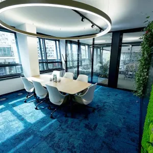 Konferenzraum mit großem Fenster, grünem Moos und Designerleuchte