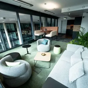 Heller Pausenraum mit Sofas, Pflanzen und Sitznische